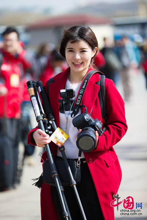 2016年兩會，人民大會大堂前，一位笑容燦爛的紅衣女記者正步入大會堂。中國網(wǎng) 鄭亮 攝
