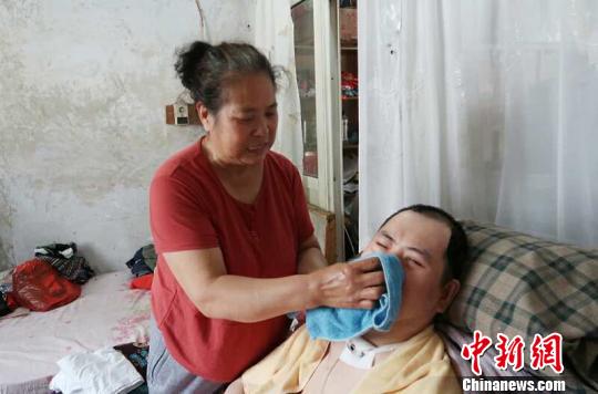 每次喂完食物后，梁青蘭都要仔細(xì)地幫兒子清理干凈。　尚明俠 攝
