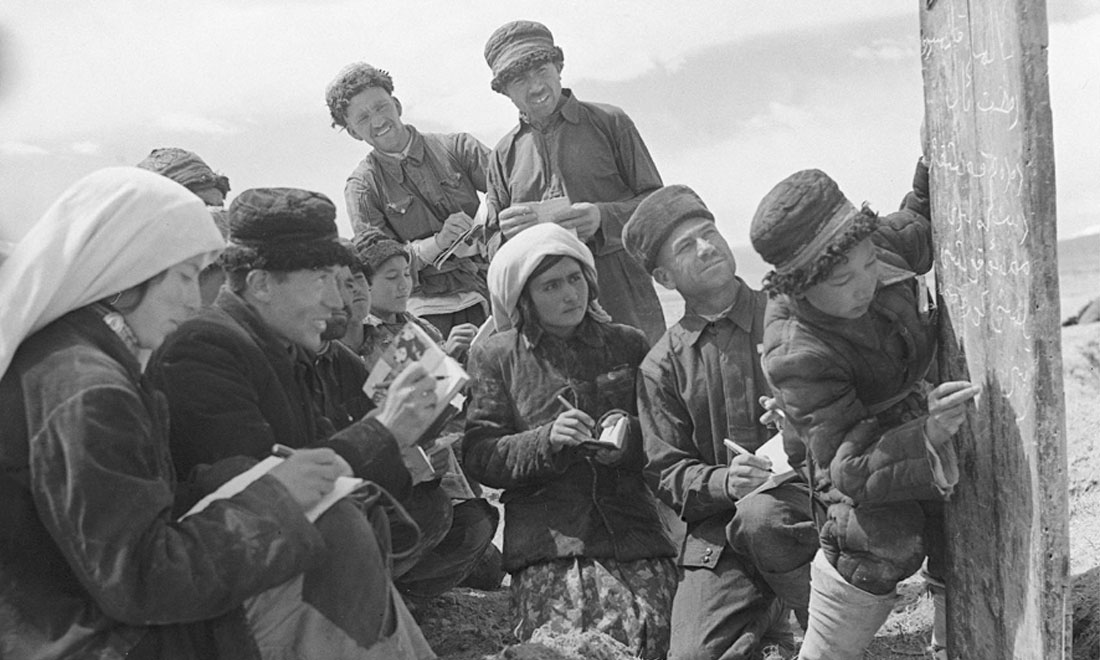 1960年6月，新疆慕士塔格峰下，大人們在小學生幫助下學習文化。新華社記者武純展攝