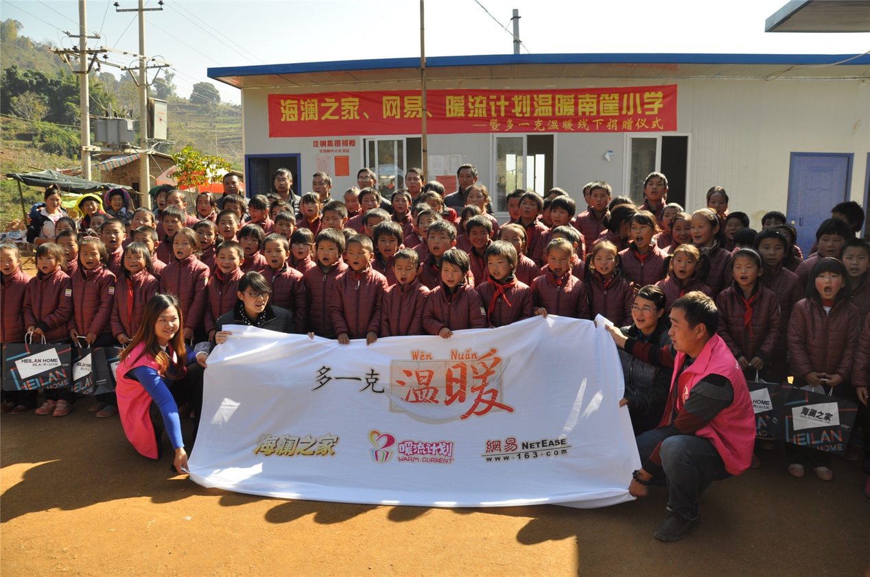 2014年11月20日，“多一克溫暖”公益團(tuán)隊來到8.3大地震的重災(zāi)區(qū)——云南省昭通市魯?shù)榭h的南筐小學(xué)。越過崎嶇山路，將一批又一批暖心羽絨服送到了師生們的手中，也將社會的關(guān)懷和愛意傳遞給了這些可愛的人。