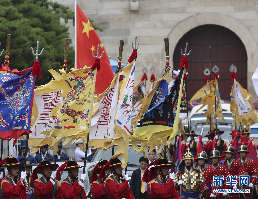 7月3日，韓國(guó)總統(tǒng)樸槿惠在青瓦臺(tái)總統(tǒng)府舉行隆重儀式，歡迎中國(guó)國(guó)家主席習(xí)近平對(duì)韓國(guó)進(jìn)行國(guó)事訪問(wèn)。這是習(xí)近平的車(chē)隊(duì)在身著民族服裝的韓國(guó)禮儀隊(duì)伍引導(dǎo)下駛?cè)肭嗤吲_(tái)。新華社記者丁林?jǐn)z  